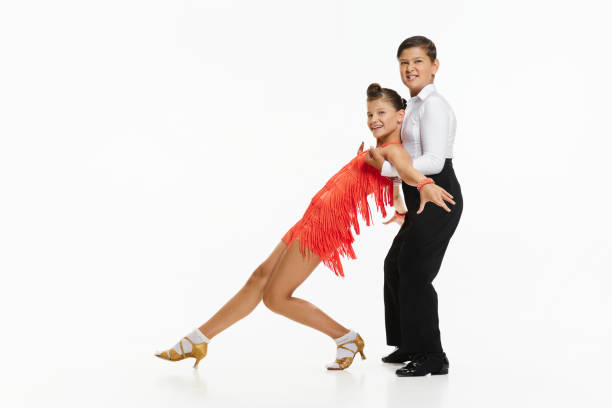 Boy and girl, children, friends making beautiful performance, dancing retro dance styles against white studio background Boy and girl, children, friends making beautiful performance, dancing retro dance styles against white studio background. Concept of childhood, hobby, active lifestyle, performance, art, fashion rockabilly boys stock pictures, royalty-free photos & images