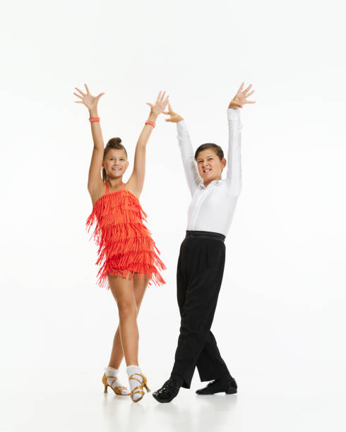 Talented, beautiful, artistic children, boy and girl in stage costumes dancing retro style dance against white studio background Talented, beautiful, artistic children, boy and girl in stage costumes dancing retro style dance over white studio background. Concept of childhood, hobby, active lifestyle, performance, art, fashion rockabilly boys stock pictures, royalty-free photos & images