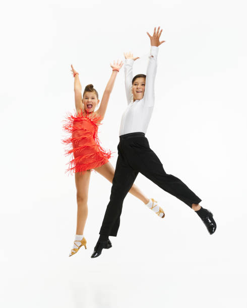 Talented, beautiful, artistic children, boy and girl in stage costumes dancing retro style dance against white studio background Talented, beautiful, artistic children, boy and girl in stage costumes dancing retro style dance over white studio background. Concept of childhood, hobby, active lifestyle, performance, art, fashion rockabilly boys stock pictures, royalty-free photos & images