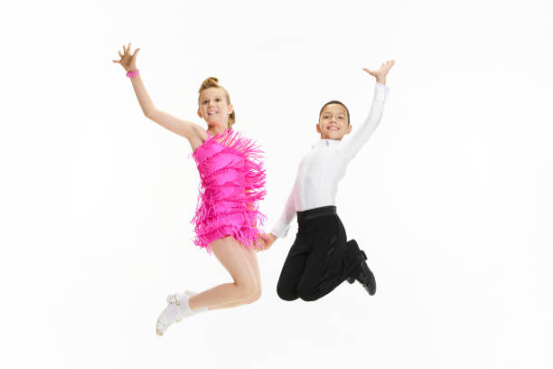 In a jump. Artistic, talented kids, boy and girl in beautiful stage costumes dancing against white studio background In a jump. Artistic, talented kids, boy and girl in beautiful stage costumes dancing against white studio background. Concept of childhood, hobby, active lifestyle, performance, art, fashion rockabilly boys stock pictures, royalty-free photos & images