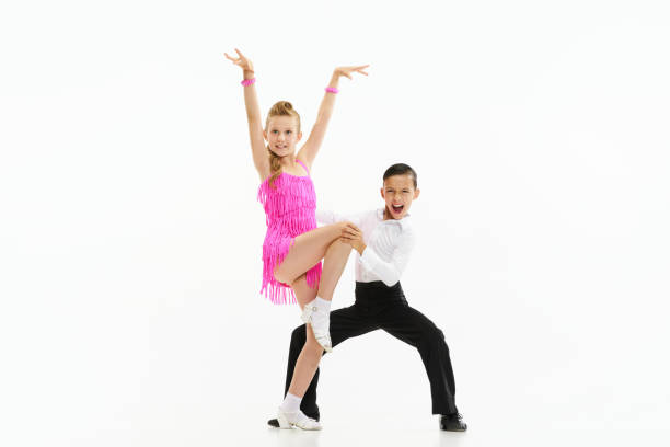 Beautiful, stylish children boy and girl dancing retro style dance, performing against white studio background Beautiful, stylish children boy and girl dancing retro style dance, performing against white studio background. Concept of childhood, hobby, active lifestyle, performance, art, fashion rockabilly boys stock pictures, royalty-free photos & images
