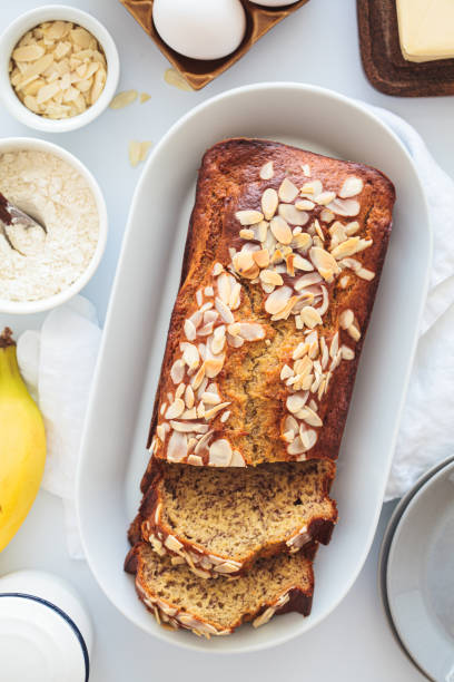 istock Banana bread with almonds on a white plate on a white background. Ingredients for home baking background. 1616281658