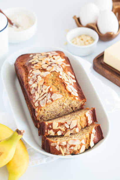istock Banana bread with almonds on a white plate on white background. 1616282227