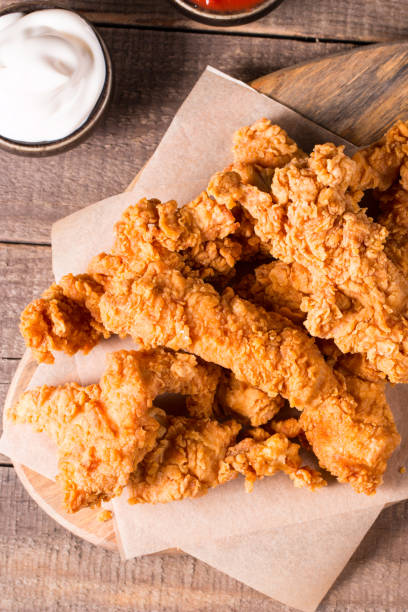 istock Crispy fried chicken breast strips with sauce 1616289580