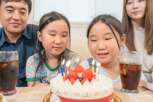 istock Young family with twins, birthday party image 1616292864