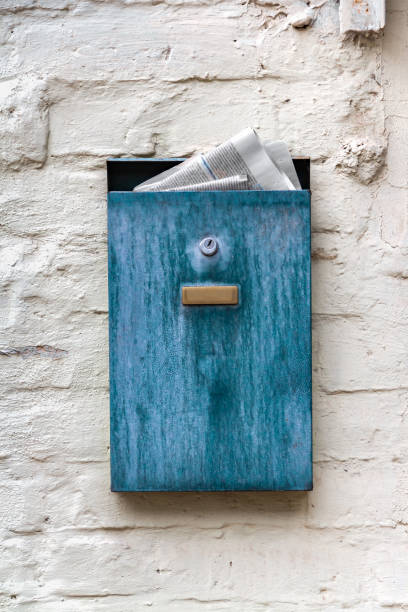 istock A blue box with a newspaper on a plastered old wall. Nastalgia. 1616313366