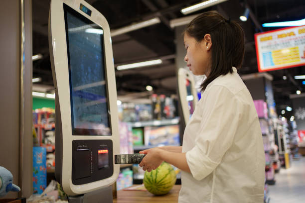 istock Woman using self-service cash register to checkout 1616313889