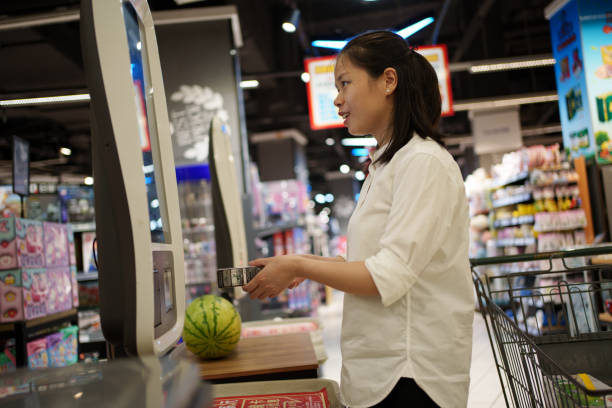 istock Woman using self-service cash register to checkout 1616314411