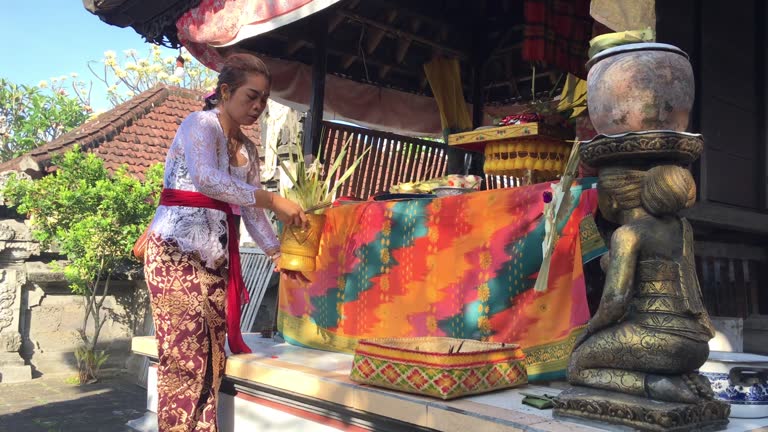 Footage of a Balinese Hindu woman making offerings at the temple