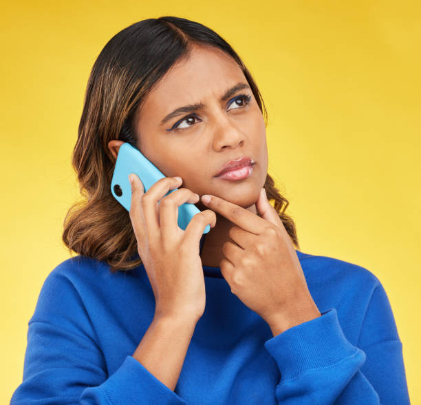 istock Phone call, thinking and woman confused, doubt and communication on a yellow studio background. Person, network and model with a smartphone, connection and spam problem with scam and conversation 1616322042