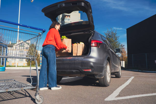 istock woman put packages in car trunk 1616355625