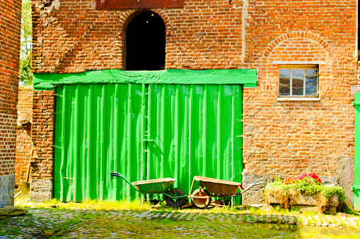 Green Barn door in a heart of a farm of Taisnières-sur-Hon north of France 12 august 2023