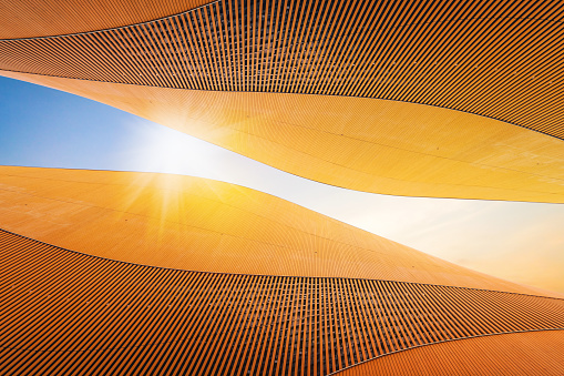 Abstract modern architecture detail with copy space. Sky and sunshine. Upward view from the ground.