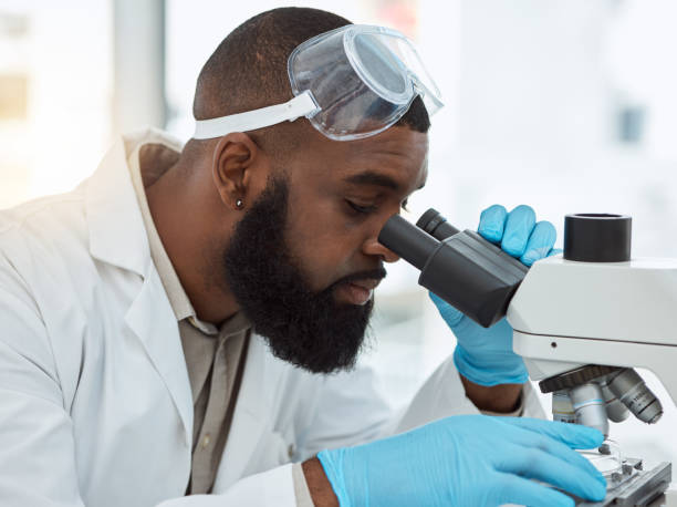 istock Microscope, medical science and a man in a laboratory for research, study and analysis or focus. Face of a black person or scientist with a scope for innovation, biotechnology and future development 1616390864