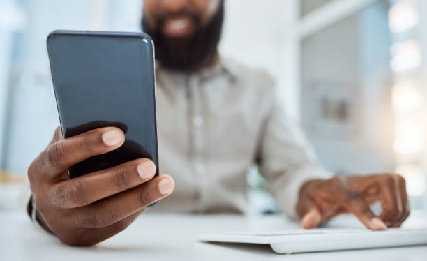 istock Business man, hands and typing on smartphone at computer in office for social network, mobile website and digital contact. Closeup of worker reading news, notification and app on cellphone at pc desk 1616400422