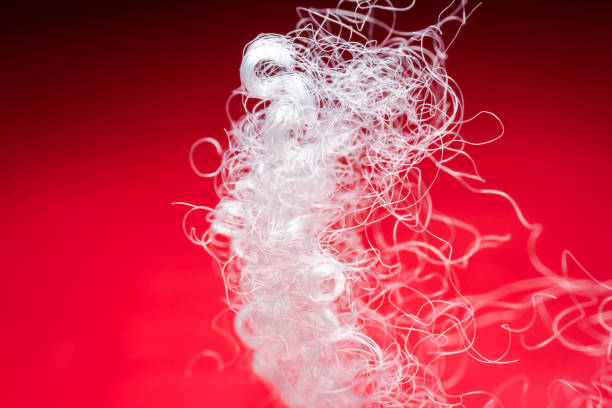 istock Extreme macro of polyester stable fiber on red background 1616463722
