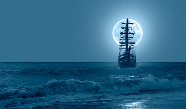 istock Sailing old ship in calm sea - Night sky with moon in the clouds 1616487606