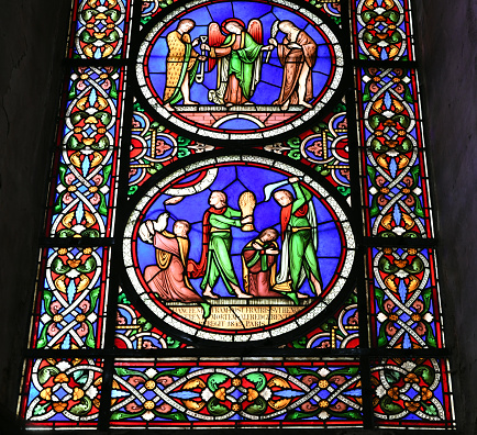 Medieval stained glass window depicting scenes from the life and martyrdom of Saint Stephen inside cathedral of York Minster in City of York, England, UK