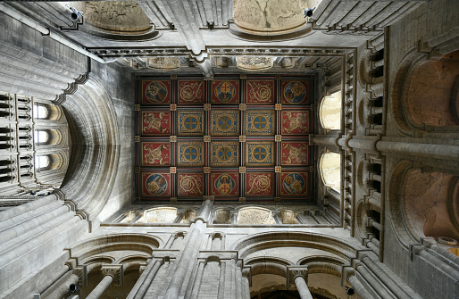 Ely Cathedral, formally the Cathedral Church of the Holy and Undivided Trinity, is an Anglican cathedral in the city of Ely, Cambridgeshire, England. Architecturally, Ely Cathedral is outstanding both for its scale and stylistic details. Having been built in a monumental Romanesque style, the galilee porch, lady chapel and choir were rebuilt in an exuberant Decorated Gothic. Its most notable feature is the central octagonal tower, with lantern above, which provides a unique internal space and, along with the West Tower, dominates the surrounding landscape.\nThe cathedral is a major tourist destination, receiving around 250,000 visitors per year.