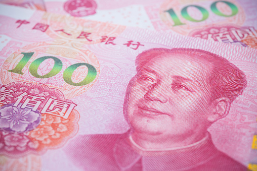 Chairman Mao (Mao Zedong) portrait on red 100 Chinese paper currency Yuan renminbi banknotes background. China or economy of Asia slow growth, global financial business, US trade war, Forex trading concept.