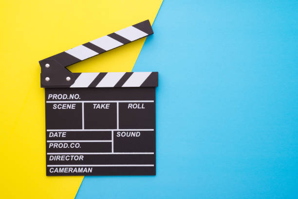 istock Cinema clapperboard on yellow blue background. 1616543146