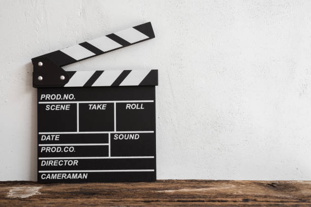 istock Cinema clapperboard on wooden with white wall background. 1616568830