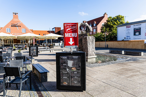 Summer restaurant on the city street. Empty restaurant summer terrace with tables and chairs. Outdoor cafe. Skagen, Denmark - August 16, 2023