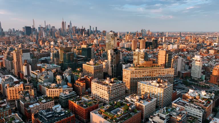 Diverse sizes and shapes of the buildings in the modern architecture of New York. Metropolis panorama from drone footage at sunset.