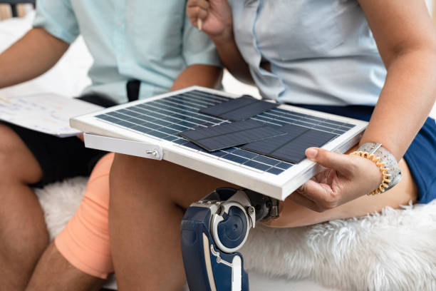 istock Unknown Woman with prosthetic working and holding solar panel at home 1616618819