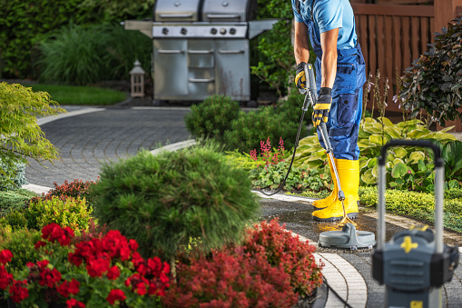 Homeowner Pressure Washing His Bricks Garden Path
