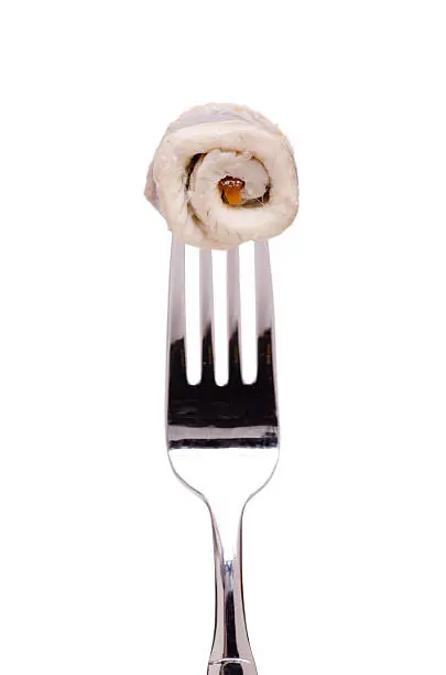 White isolated rolled pickled Herring on a fork