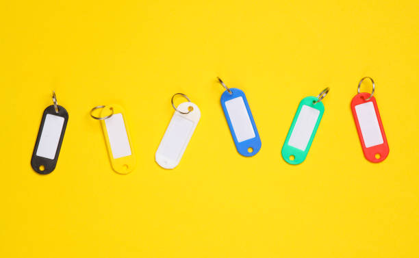 Tags key ID. different color  keychains with white space for text. Template for design. Yellow background stock photo