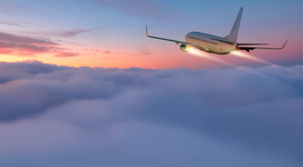 istock Airplane flying over tropical sea at sunset 1616670990