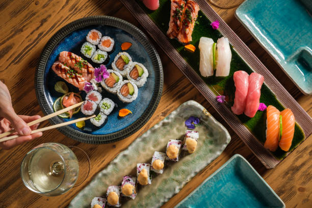 istock Person taking maki sushi roll from plate 1616721707