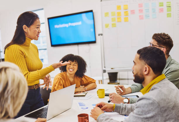 istock Female consultant smiling and explaining business plan at team meeting 1616721832