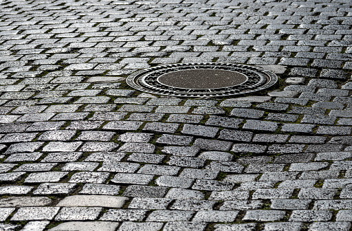 Street with stone paving and manhole cover, Germany Leipzig downtown