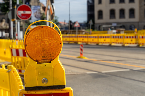 Yellow lamp of a construction site barrier on the street, Germany Leipzig downtown