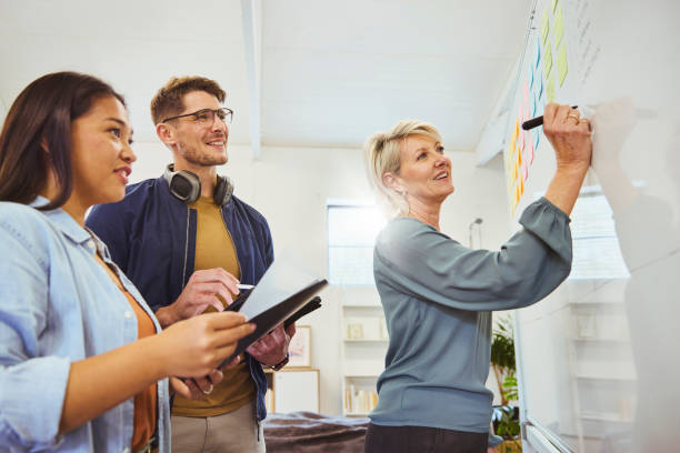 istock Low angle view of creative manager writing on whiteboard at team meeting 1616722118