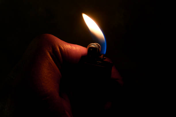 istock A hand figure lights a fire with a lighter in the darkness. 1616741956