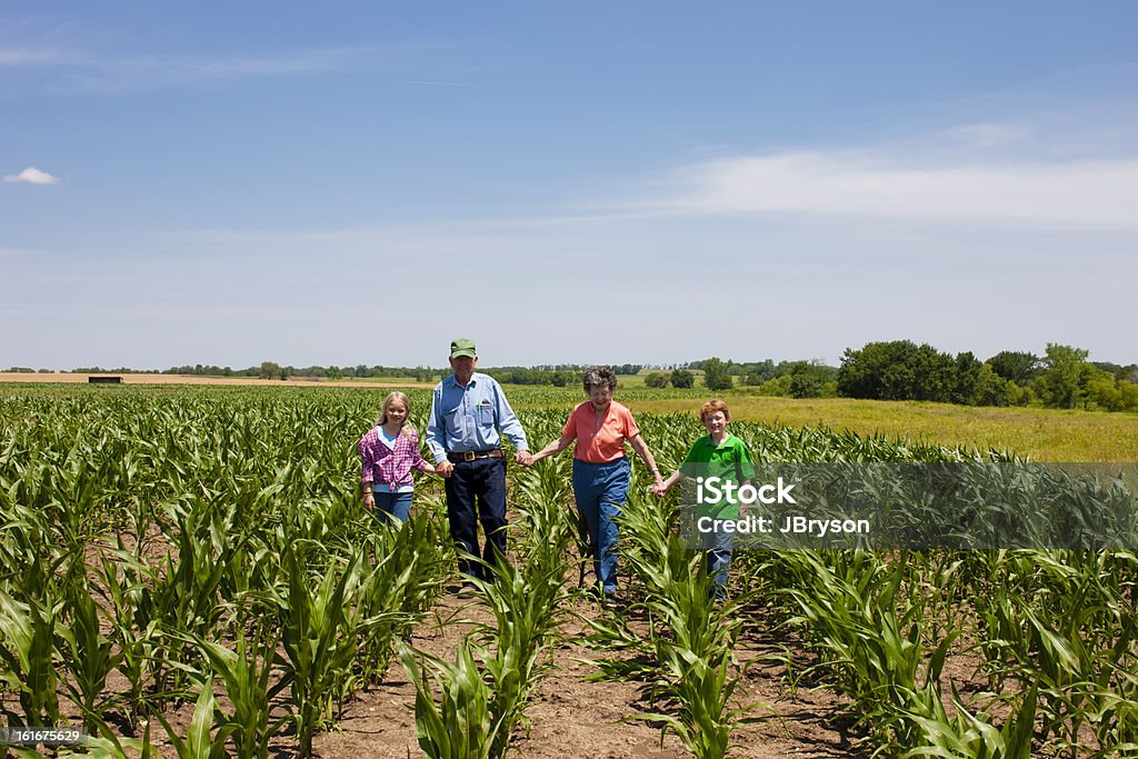 Esforço dos seus avós agricultores Casal caminhando com netos - Foto de stock de Família royalty-free