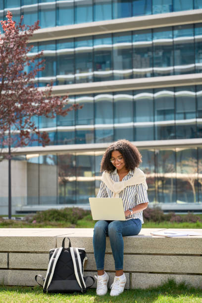 istock Young happy African American girl student using laptop studying in park. 1616756533