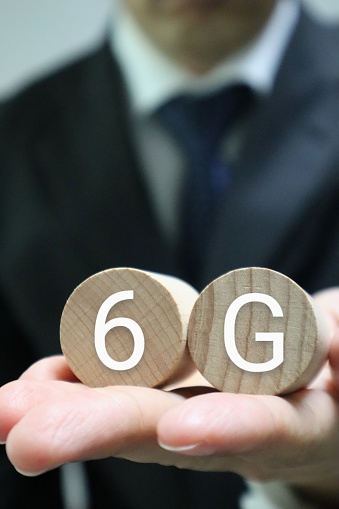 Photo of a person holding a building block labeled 6G