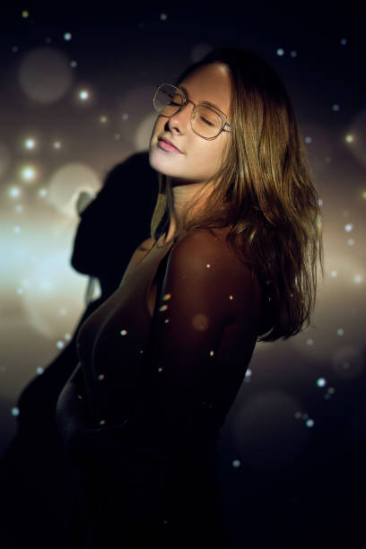 istock Young female with closed eyes under sparks 1616798087