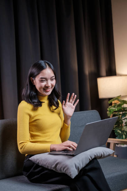 istock Asian young woman chatting online on laptop computer while sitting on sofa late at night 1616807142