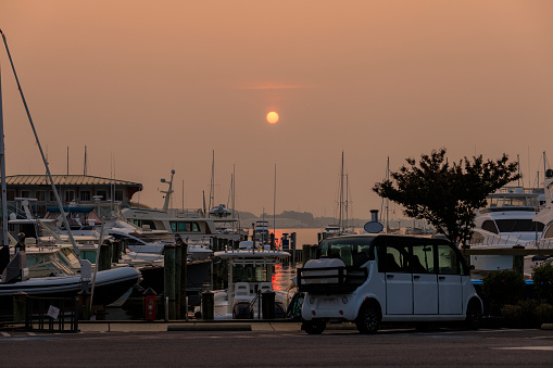 Harbor at sunset: Boats and yachts in moored in the harbor on the water bay, Severn River, Annapolis, MD. Canadian wildfires smog aftermath.