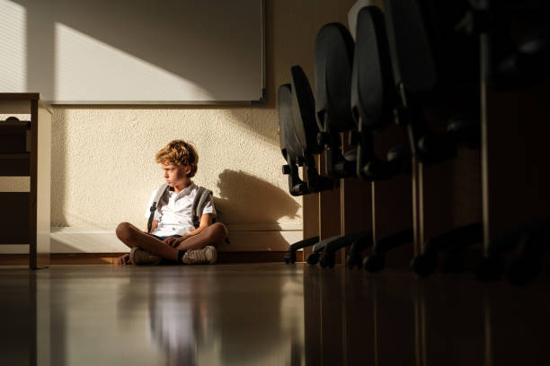 istock Sad schoolboy sitting alone in classroom 1616811913