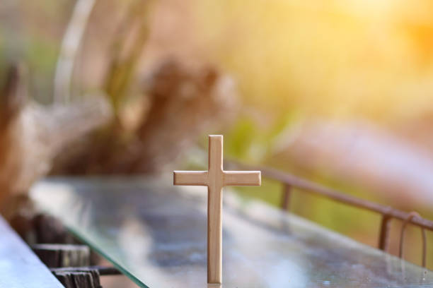istock cross representing God in Christianity is placed on mirror and its reflection can be seen on blurred background of nature. cross on background is blurred and there is Copy Space on side for text. 1616826510