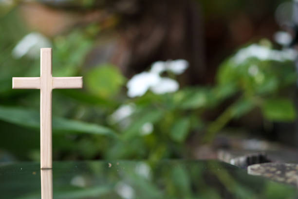 istock cross representing God in Christianity is placed on mirror and its reflection can be seen on blurred background of nature. cross on background is blurred and there is Copy Space on side for text. 1616829225