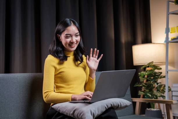 istock Asian young woman chatting online on laptop computer while sitting on sofa late at night 1616831838