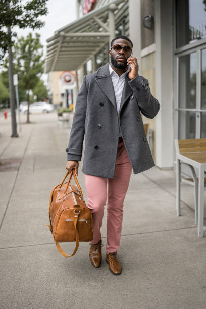istock Young man walks downtown on the phone, carrying a bag 1616871885